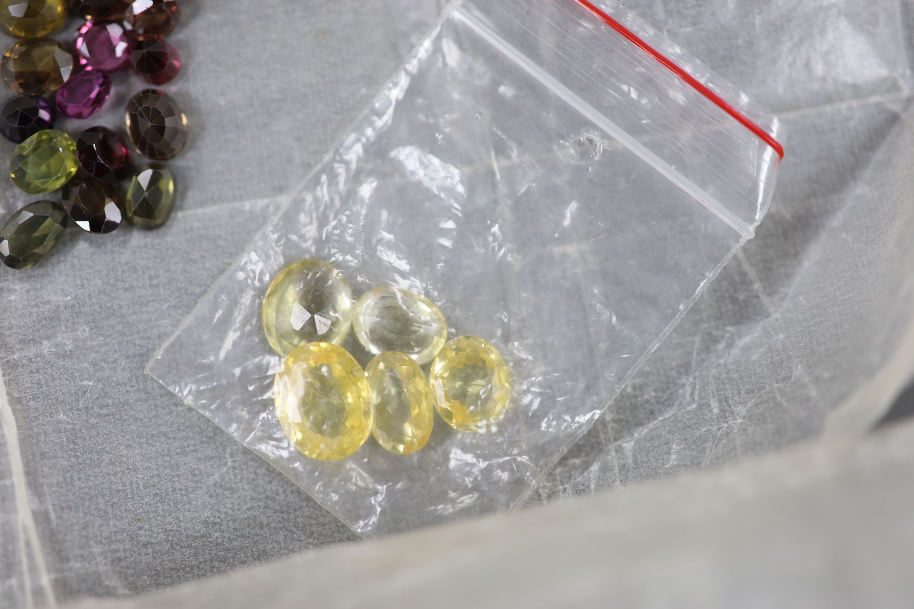 A quantity of assorted loose cut gemstones including sapphires, aquamarine, citrine and tourmalines.